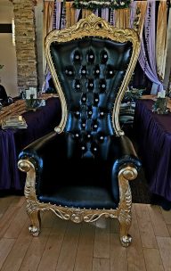 Black and Gold Throne Chair Luxurious black and gold throne with ornate details and tufted upholstery.