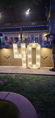 Light up Wood number marquess Large light-up sign displaying the number "40" at a celebration.